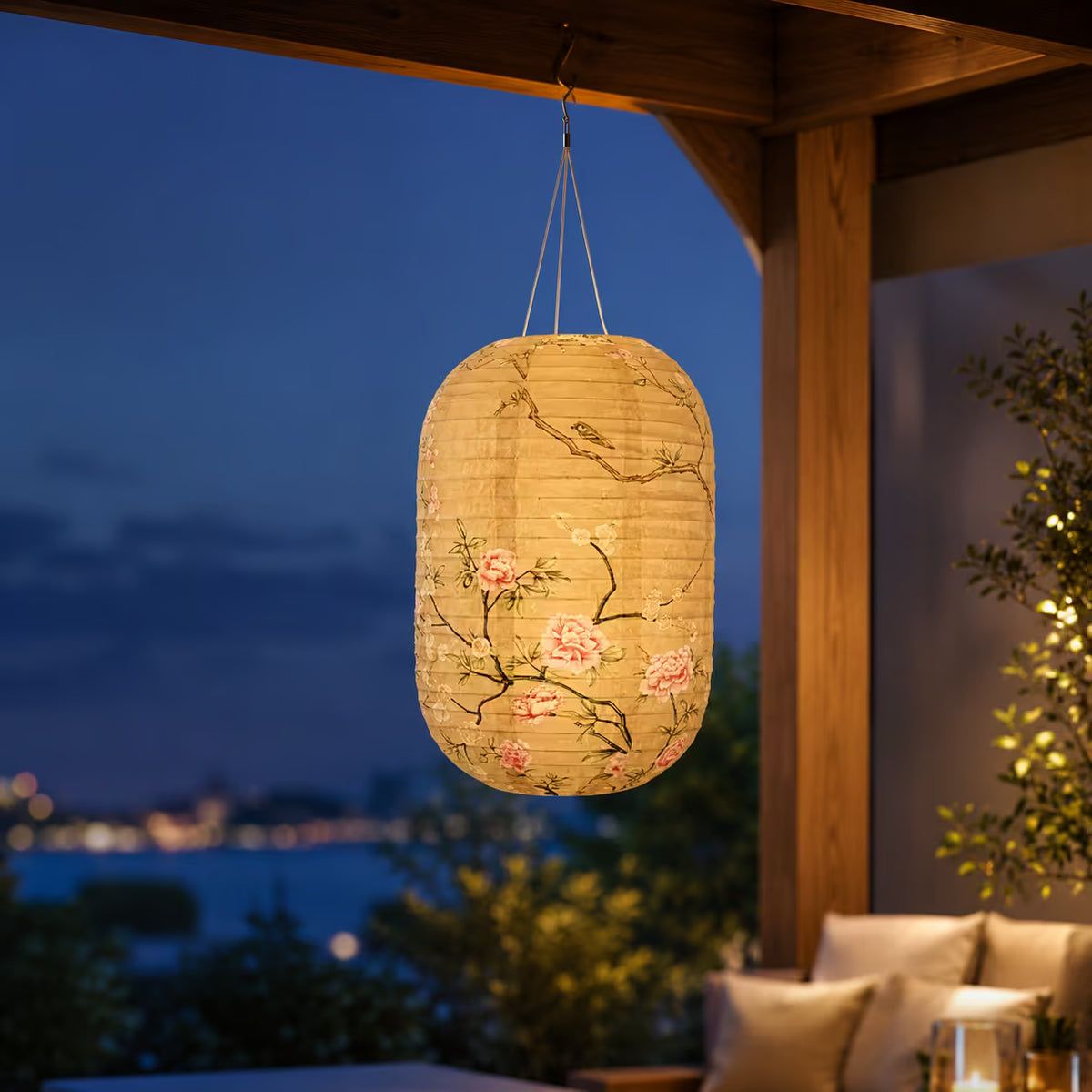 Japanische Solar-Hängelaterne Kirschblüte Beige beleuchtet eine Terrasse am Abend mit Meerblick