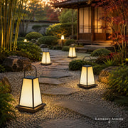 Mehrere Japan Garten Laternen Solar mit warmem Licht entlang eines Gartenwegs