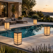 Mehrere japanische Solar-Laternen mit warmem Licht auf einer modernen Terrasse am Pool