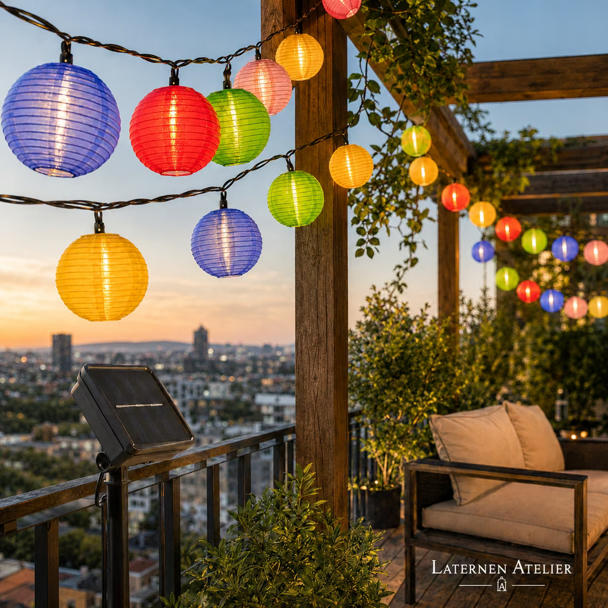 Bunte Papier-Lampion-Lichterkette beleuchtet eine Dachterrasse bei Nacht mit Stadtblick