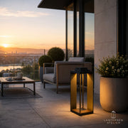 Schwarze Solar-Laterne mit warmem Licht auf moderner Terrasse und Lounge-Bereich