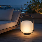 Solar-Akku-Laterne Schwarz mit warmem Licht neben Outdoor-Lounge auf Terrasse