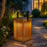Solar-Bambuslaterne mit warmem Licht im Garten neben Blumen und Grünpflanzen