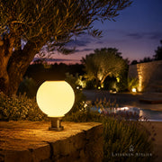 Solar-Kugellaterne mit warmem Licht auf einer mediterranen Terrasse mit Gartenblick