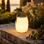 Solar-LED-Laterne Weiß neben Outdoor-Lounge mit warmem dekorativem Licht