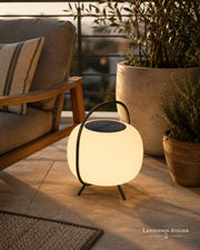 Solar-LED Laterne mit warmem Licht auf einer modernen Terrasse neben Outdoor-Möbeln