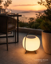 Solar-LED Laterne für Balkon mit warmem Licht neben Pflanzen bei Sonnenuntergang