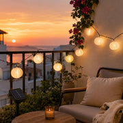 Solar-Lampion-Lichterkette Weiß mit warmem Licht auf Balkon bei Sonnenuntergang