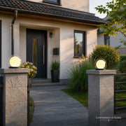 Solar-Laterne Outdoor mit rundem Lichtdesign auf einer Gartenmauer vor dem Hauseingang
