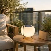 Modernes Solar-Windlicht mit warmem Licht auf einem Gartentisch auf der Terrasse