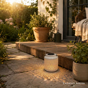 Weiße Solar-Laterne mit warmem Licht auf einem Gartenweg im Außenbereich