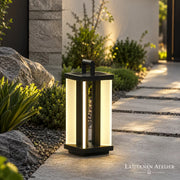 Solar Outdoor Laterne aus Metall mit warmem Licht neben einem Gartenweg