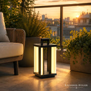 Solar Outdoor Laterne aus Metall mit warmem Licht neben einer Outdoor-Lounge auf der Terrasse