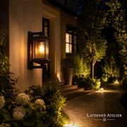 Außen-Wandlaterne aus Aluminium und Glas mit warmem Licht am Gartenweg