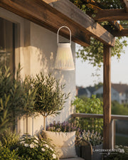 Weißes Solar-Windlicht zum Aufhängen mit warmem Licht auf einer Terrasse