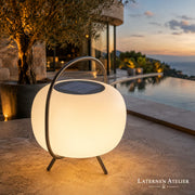 Modernes Solar-Windlicht mit rundem Lichtkörper auf einer Terrasse am Pool