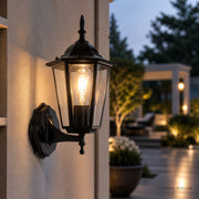 Schwarze Retro Wandlaterne mit warmem Licht auf Terrasse bei Abendstimmung für Außenbereich